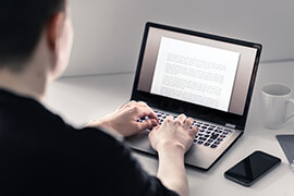 A close-up of a Content Editor working on his laptop.