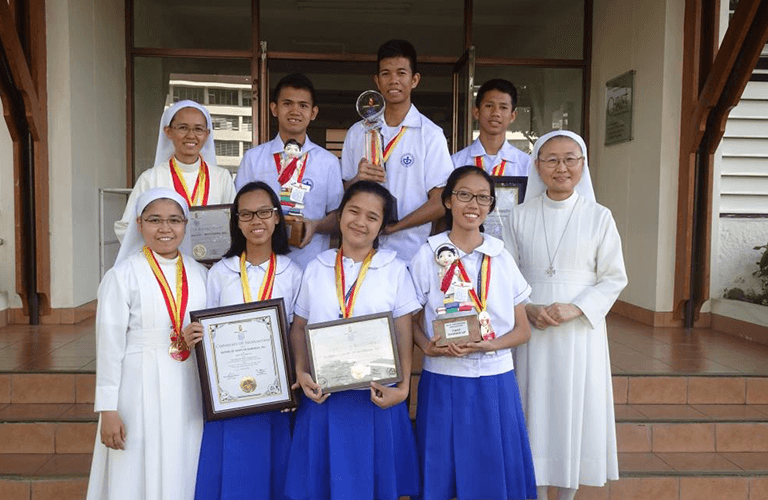 A full shot of students and nuns of the Sisters of Mary with their achievement medals and awards.
